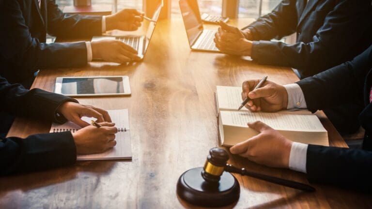 Equipo de abogados brindando asesoría legal a empresarios para evitar sanciones y cumplir con las normativas legales vigentes