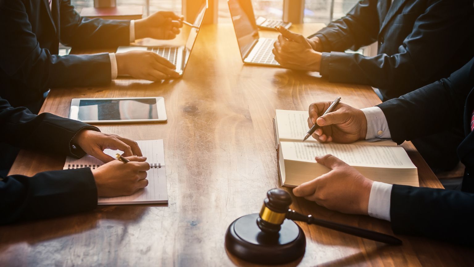 Equipo de abogados brindando asesoría legal a empresarios para evitar sanciones y cumplir con las normativas legales vigentes