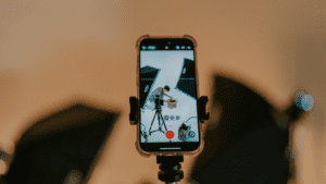 Grabación con móvil en estudio de vídeo donde se enfoca a una persona preparando una caja frente a focos de iluminación profesional.