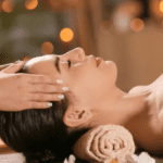 Mujer disfrutando de un masaje facial relajante en spa con ambiente cálido y velas en Barcelona para cuidado integral del rostro y bienestar emocional.