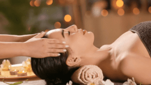 Mujer disfrutando de un masaje facial relajante en spa con ambiente cálido y velas en Barcelona para cuidado integral del rostro y bienestar emocional.