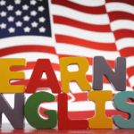 Letras de colores formando la frase "Learn English" frente a una bandera de Estados Unidos como símbolo del aprendizaje del inglés en un contexto lúdico y educativo.