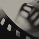 Carrete de película en blanco y negro representando el cine analógico y la producción cinematográfica clásica.