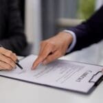 Firma de contrato laboral entre empresa y trabajador con asesoría legal para evitar problemas jurídicos en la contratación