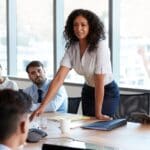Líder consciente guiando a su equipo en una reunión colaborativa en la oficina, representando una cultura empresarial positiva y humana.