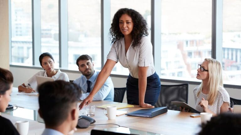 Líder consciente guiando a su equipo en una reunión colaborativa en la oficina, representando una cultura empresarial positiva y humana.
