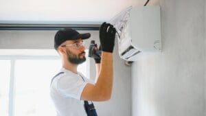 Técnico revisando aire acondicionado con mal olor en una vivienda de Tarragona.