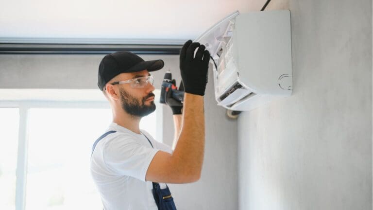 Técnico revisando aire acondicionado con mal olor en una vivienda de Tarragona.