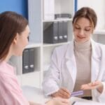 Mujer joven consultando con su ginecóloga en clínica privada, reflejando prevención y cuidado de la salud femenina con confianza y cercanía