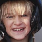 Niño con casco de moto infantil homologado viajando seguro como pasajero