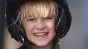 Niño con casco de moto infantil homologado viajando seguro como pasajero
