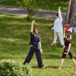 Mujer practicando movimientos somáticos para reducir el estrés en un ambiente relajado y natura
