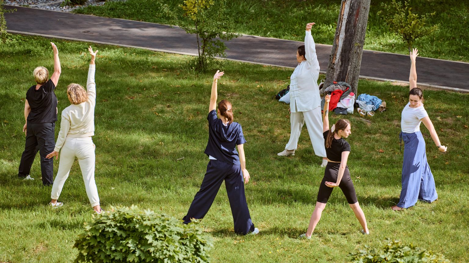 Mujer practicando movimientos somáticos para reducir el estrés en un ambiente relajado y natura