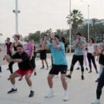 Personas entrenando al aire libre en un parque o zona cercana a la playa en Málaga, como alternativa al gimnasio tradicional.