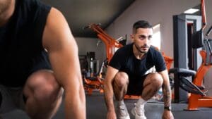 Entrenador personal ayudando a evitar lesiones durante un ejercicio sencillo.