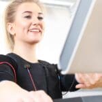 Persona entrenando con entrenador personal en sesión exprés con tecnología de resistencia adaptativa