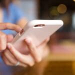 Persona enviando dinero desde su móvil con una app financiera digital