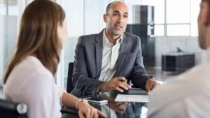 Reunión entre asesor financiero y cliente planificando inversiones y gestión patrimonial