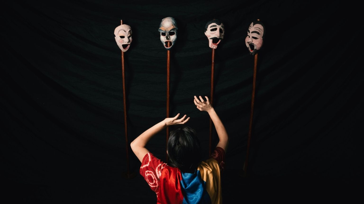 Escena de una función de teatro en vivo en España con actores interpretando sobre un escenario iluminado ante el público