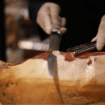 Paleta de bellota 100 ibérica en tabla con cuchillo jamonero.