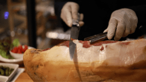 Paleta de bellota 100 ibérica en tabla con cuchillo jamonero.