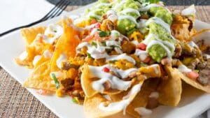 Plato de nachos mexicanos con guacamole, queso fundido y jalapeños en restaurante de Bilbao