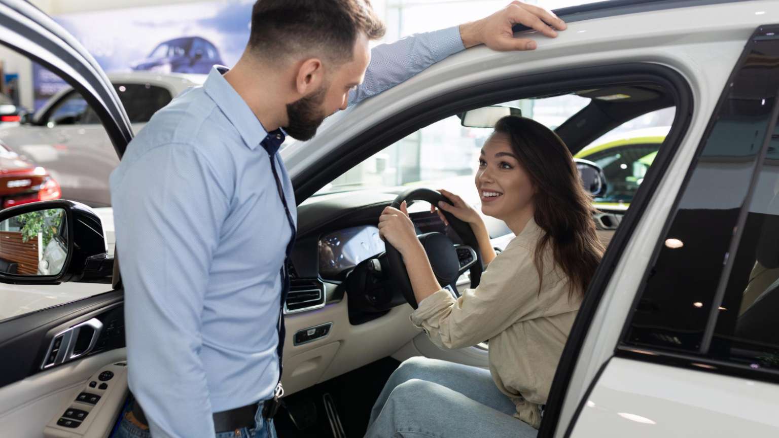 Persona revisando un coche de segunda mano en concesionario de Valladolid, inspeccionando interior y exterior del vehículo antes de comprar.
