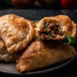 Mesa rústica con empanadas argentinas, tartas saladas y postres típicos sudamericanos presentados de forma artesanal