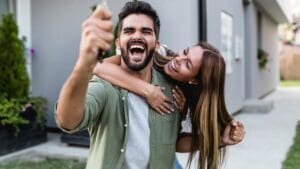 Pareja joven comprando vivienda nueva directamente a grupo inmobiliario en promoción moderna