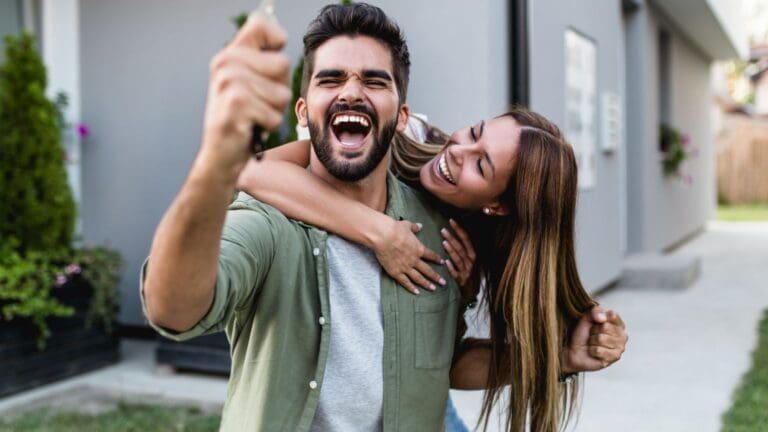 Pareja joven comprando vivienda nueva directamente a grupo inmobiliario en promoción moderna