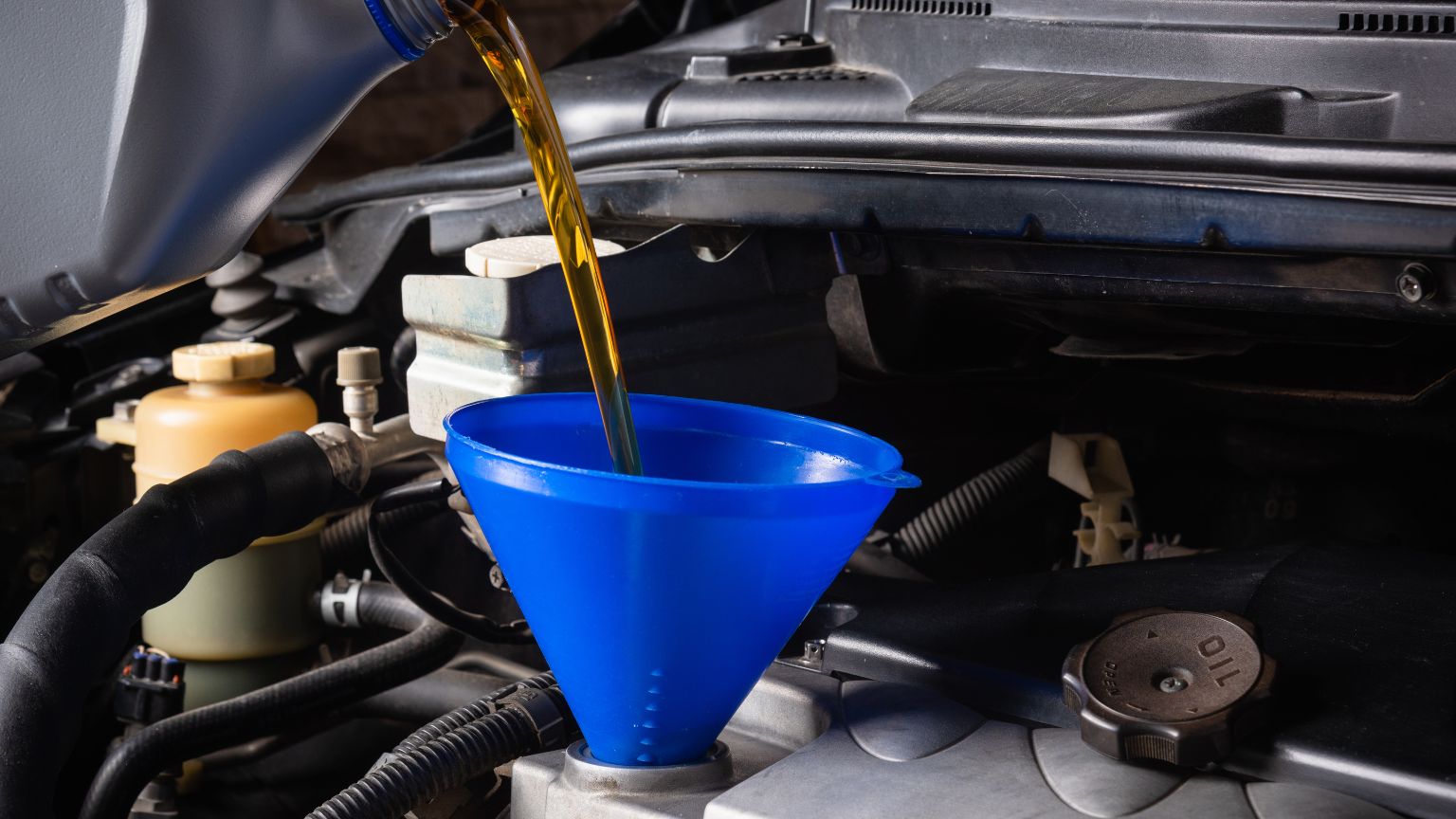 Mecánico cambiando el aceite del coche para mantener el motor en buen estado