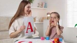 Niño sonriente recibiendo apoyo de una logopeda en casa
