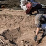 Arqueólogos realizando intervención arqueológica obligatoria en una obra urbana en España.