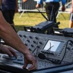 Equipo técnico preparando la producción audiovisual de un evento en vivo con escenografía, iluminación profesional y planificación estratégica