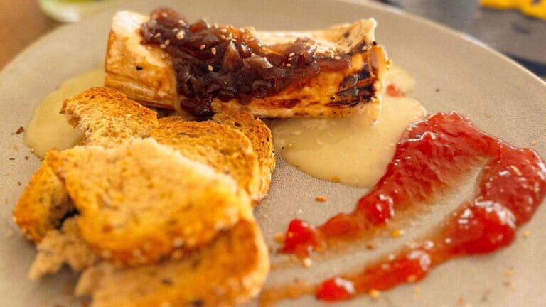 Plato de brunch con tostadas crujientes, queso a la plancha y acompañamientos servidos en un restaurante con propuesta gastronómica relajada