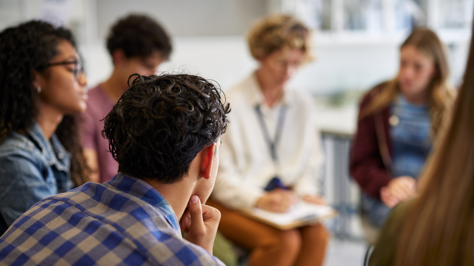 Family therapy session, family sitting with therapist, group counseling