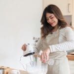 Mujer cocinando de forma intuitiva en casa, disfrutando del proceso sin seguir una receta