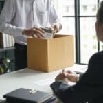 Trabajador afectado por despido injusto recibiendo asesoramiento legal profesional en una oficina