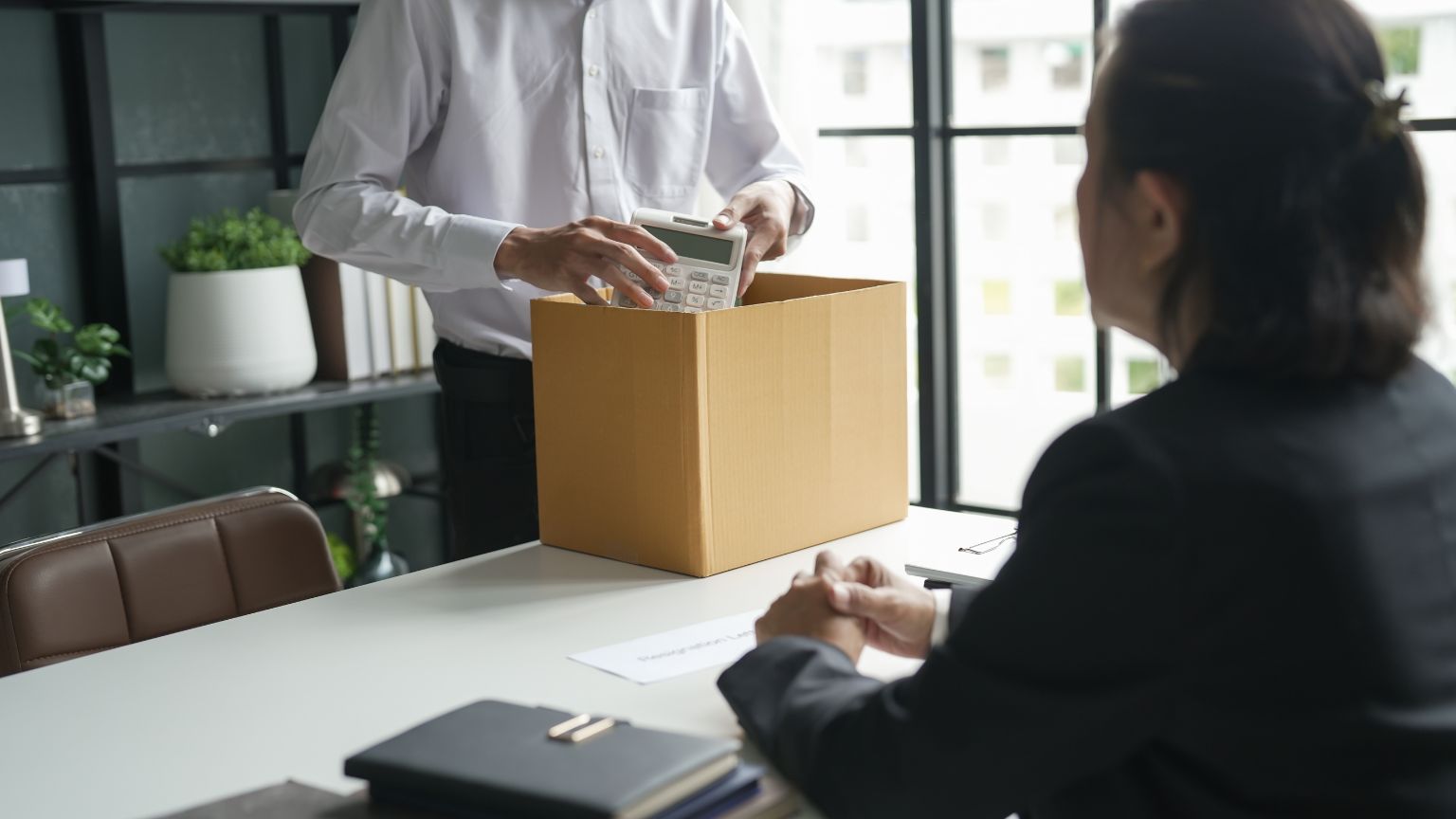 Trabajador afectado por despido injusto recibiendo asesoramiento legal profesional en una oficina