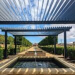 Pérgola de madera instalada en jardín moderno como ejemplo de estructura exterior personalizada
