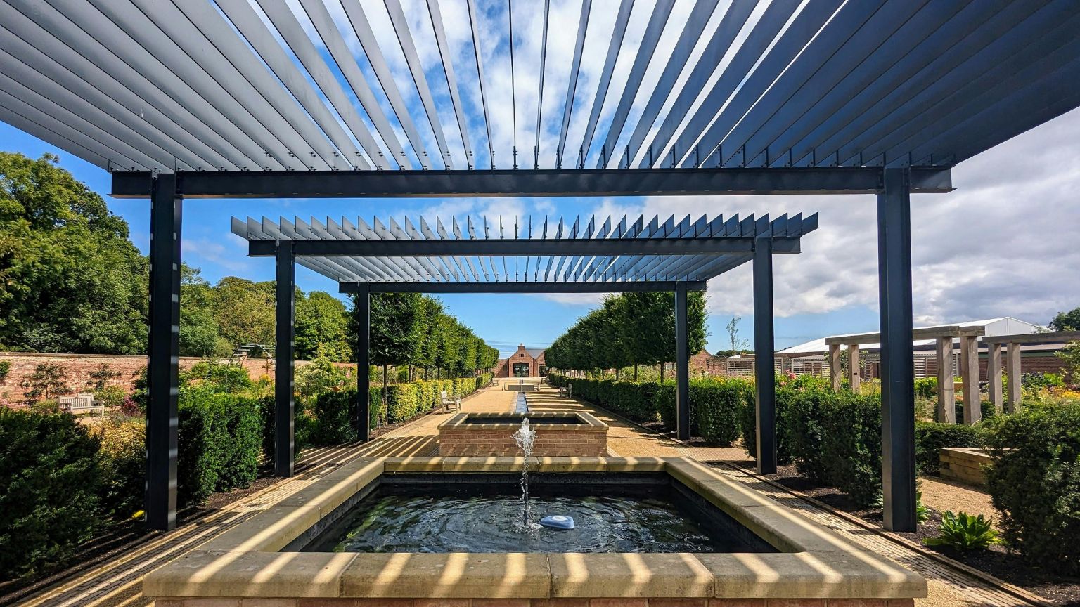 Pérgola de madera instalada en jardín moderno como ejemplo de estructura exterior personalizada