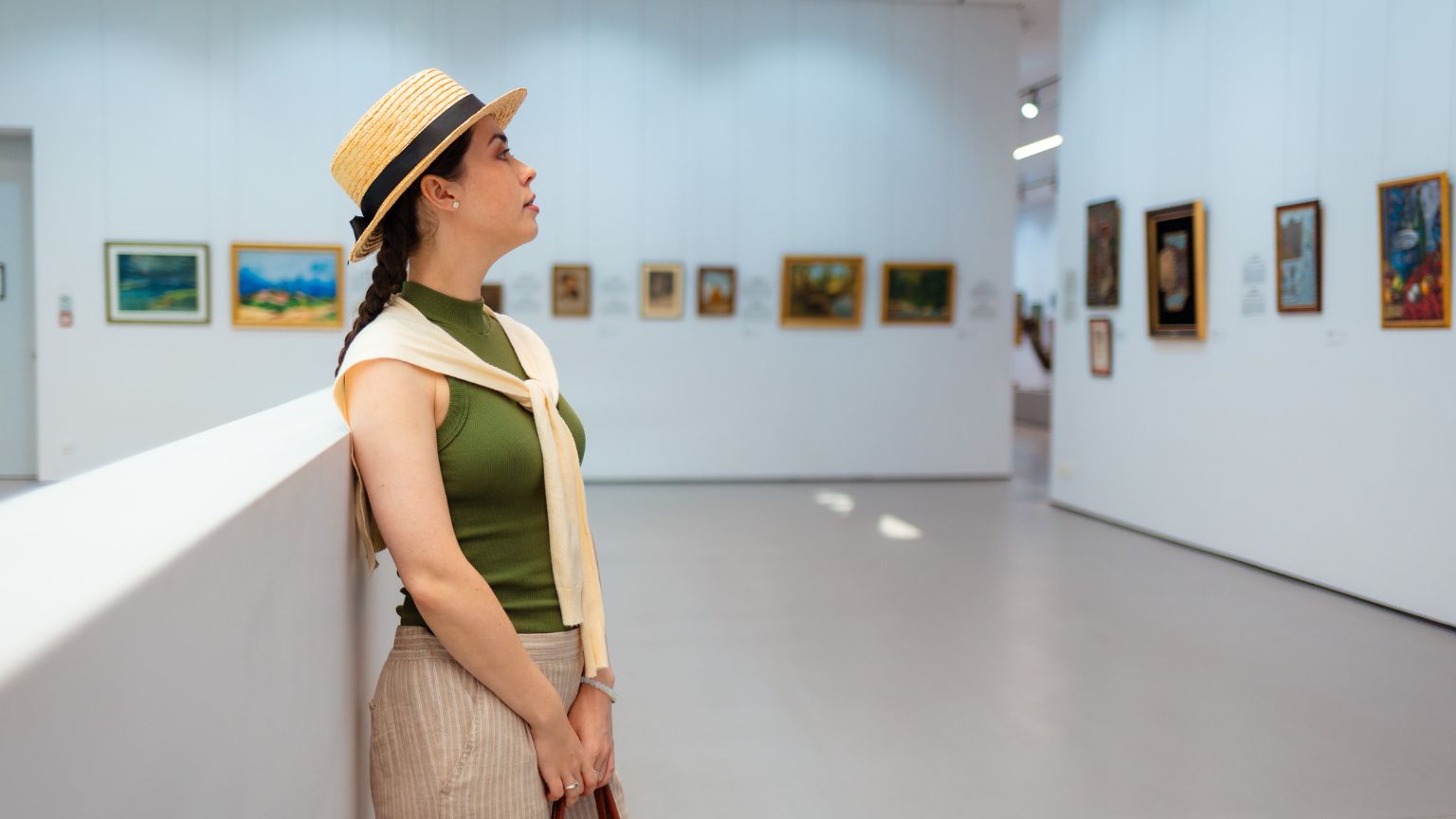 Persona observando una obra en una galería durante su inicio en el coleccionismo de arte