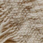 Arte textil integrado en interiorismo contemporáneo con iluminación artística que resalta esculturas textiles en un espacio moderno.