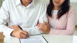 Pareja revisando documentos para comprar piso con asesor inmobiliario en el mercado inmobiliario