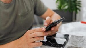 Usuario revisando un teléfono móvil como parte del uso cotidiano relacionado con la reparación de móviles y tablets