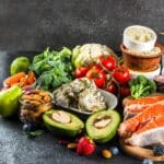 Planes de alimentación personalizados con alimentos saludables como salmón, verduras frescas, frutas y frutos secos para mejorar el bienestar diario