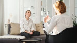 Mujer reflexionando en casa durante una crisis existencial a los 30 o 40 buscando mentoría de crecimiento personal