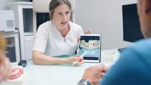 Paciente en clínica dental recibiendo información sobre implantes dentales y recuperación para mejorar su salud bucodental