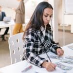 Estudiante extranjero realizando prácticas profesionales en España en oficina moderna con equipo de trabajo