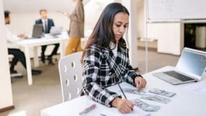 Estudiante extranjero realizando prácticas profesionales en España en oficina moderna con equipo de trabajo